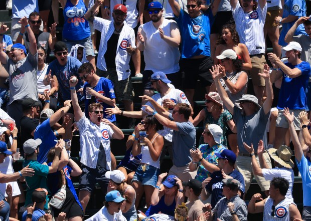 A fan celebrates after catching a home run ball from Cubs right fielder Kyle Tucker in the first inning against the Mariners on June 21, 2025, at Wrigley Field. (John J. Kim/Chicago Tribune)