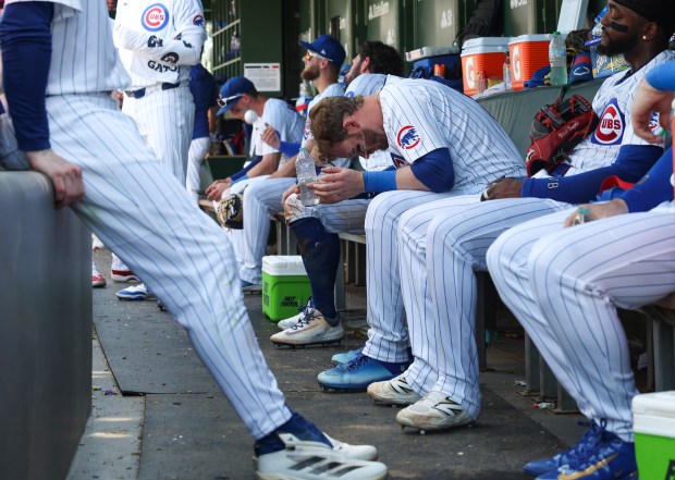 Cubs left fielder Ian Happ, center, cools off with a bottle of water during a temporary stoppage in play in the sixth inning against the Mariners on June 21, 2025, at Wrigley Field. (John J. Kim/Chicago Tribune)