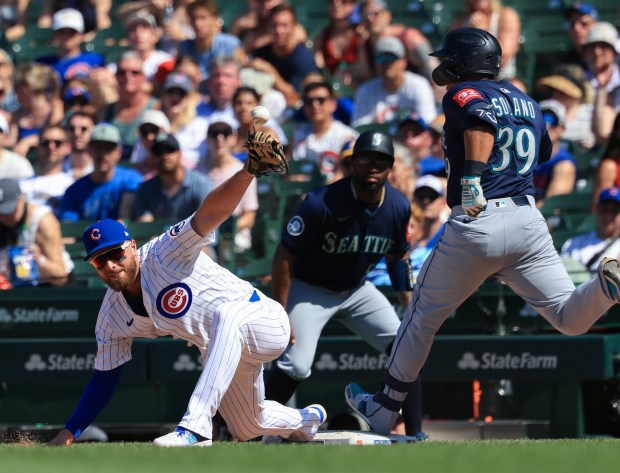 Cubs first baseman Michael Busch cannot catch the throw as Mariners first baseman Donovan Solano reaches for a single in the seventh inning on June 21, 2025, at Wrigley Field. (John J. Kim/Chicago Tribune)