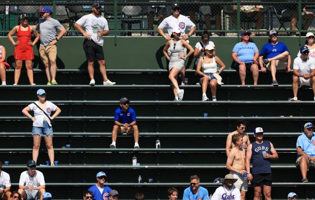Fans in the right-field bleachers stand to avoid hot metal seats in the seventh inning of a Cubs-Mariners game on June 21, 2025, at Wrigley Field. (John J. Kim/Chicago Tribune)
