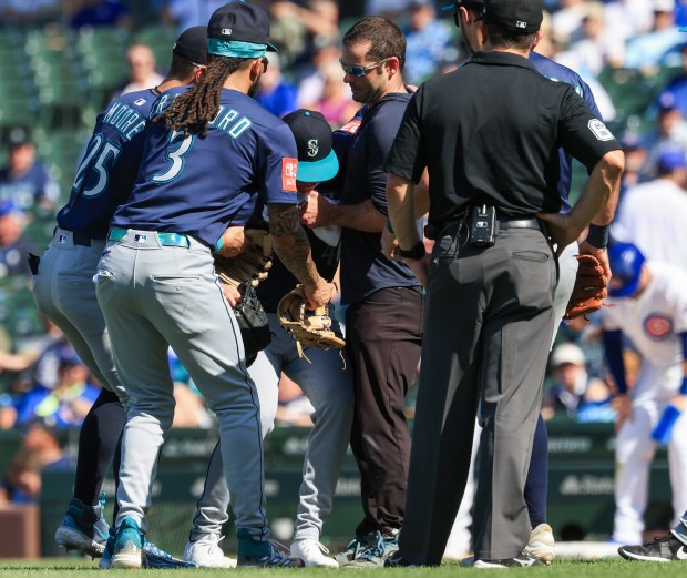 Mariners pitcher Trent Thornton, center, loses his balance as teammates keep him from falling in the eighth inning against the Cubs on June 21, 2025, at Wrigley Field. (John J. Kim/Chicago Tribune)