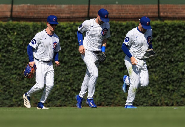 Cubs center fielder Pete Crow-Armstrong, from left, right fielder Kyle Tucker and left fielder Ian Happ head to the infield after a 10-7 win over the Mariners on June 21, 2025, at Wrigley Field. (John J. Kim/Chicago Tribune)