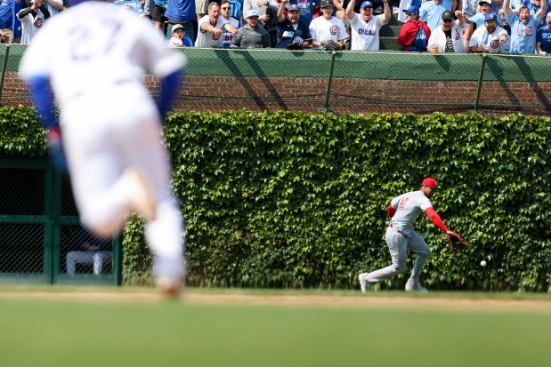 Cincinnati Reds outfielder Will Benson (30) runs after the ball after making an error as Chicago Cubs DH Seiya Suzuki (27) runs to second base during the seventh inning at Wrigley Field on Sunday, June 1, 2025. (Eileen T. Meslar/Chicago Tribune)
