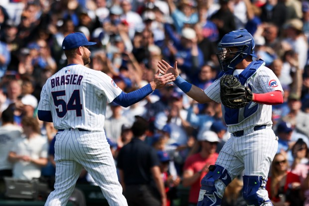 Chicago Cubs pitcher Ryan Brasier (54) and Chicago Cubs catcher Reese McGuire (20) high-five after Brasier struck out the final batter to win the game against the Cincinnati Reds at Wrigley Field on Sunday, June 1, 2025. (Eileen T. Meslar/Chicago Tribune)