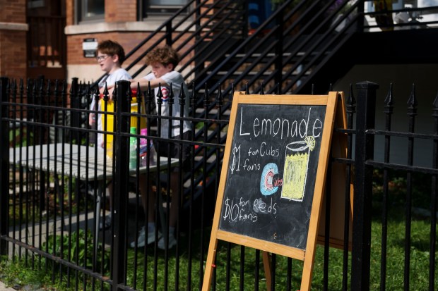 Chicago Cubs fans Declan Fleming and Patrick McTaggart sell lemonade near Wrigley Field on Sunday, June 1, 2025, after the Chicago Cubs defeated the Cincinnati Reds 7-3. (Eileen T. Meslar/Chicago Tribune)