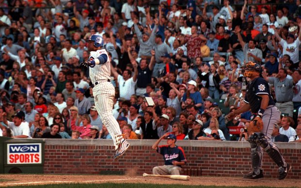 Cubs slugger Sammy Sosa leaps as he and fans watch his 60th home run fly through the air against the Brewers on Sept. 18, 1999, at Wrigley Field. (John Lee/Chicago Tribune)