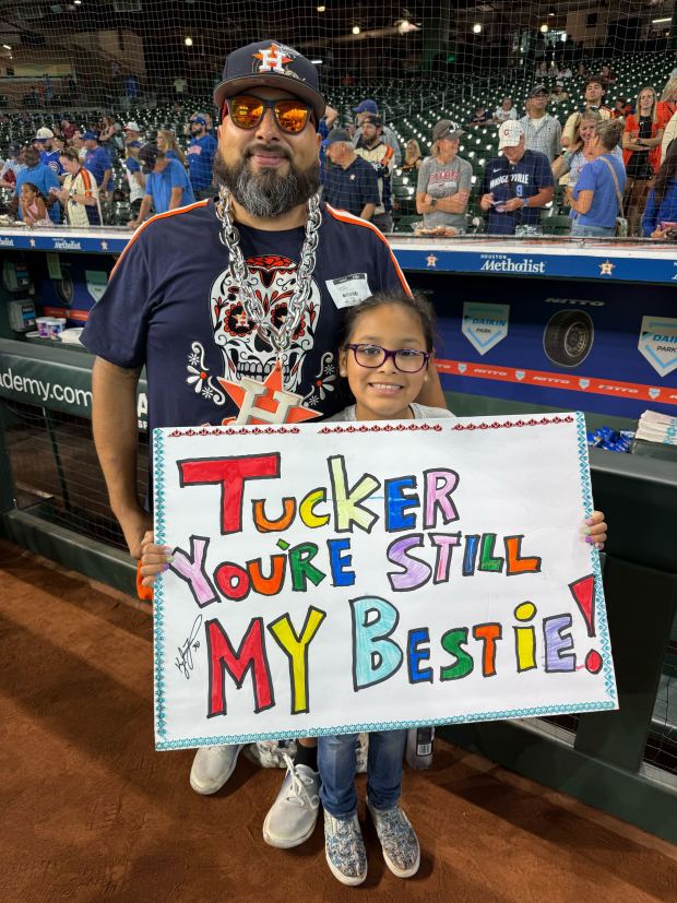 Antonio Gonzales, 45, and his daughter Grace, 9, of South Houston pose with her sign for Kyle Tucker, who signed it before the Chicago Cubs' series opener against the Houston Astros on Friday, June 27, 2025, at Daikin Park in Houston. (Meghan Montemurro/Chicago Tribune)
