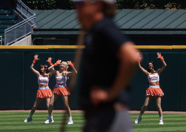Members of a Taiwanese cheerleading squad named "Uni-Girls" perform in the outfield on Taiwan Day at Rate Field as a grounds crew worker waits before a White Sox-Giants game Saturday, June 28, 2025. (John J. Kim/Chicago Tribune)