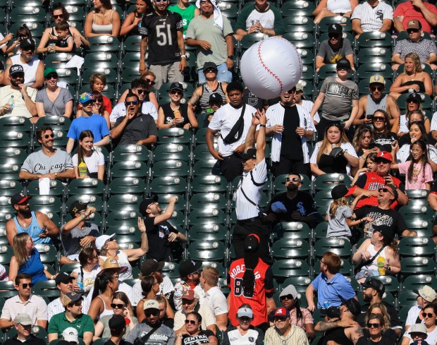 A security worker tries to grab an inflatable baseball balloon as fans play keep-away in the bleachers in the seventh inning of a White Sox-Giants game Saturday, June 28, 2025, at Rate Field. (John J. Kim/Chicago Tribune)