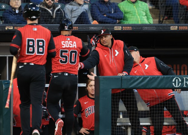 White Sox second baseman Lenyn Sosa (50) is congratulated by manager Will Venable after scoring on a bases-loaded walk in the third inning against the Rangers on May 23, 2025, at Rate Field. (John J. Kim/Chicago Tribune)