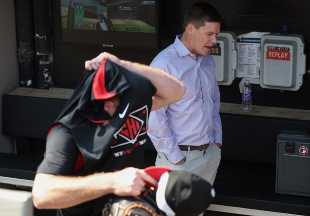 White Sox general manager Chris Getz talks with a reporter as catcher Kyle Teel takes off his practice jersey before a game against the Royals on June 6, 2025, at Rate Field. (John J. Kim/Chicago Tribune)