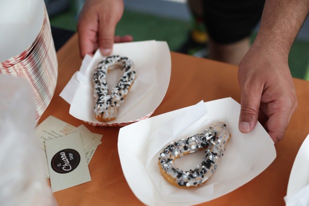 Churros decorated in White Sox colors are handed out in a parking lot before a White Sox-Royals game on Mexican Heritage Night at Rate Field on June 6, 2025. (John J. Kim/Chicago Tribune)