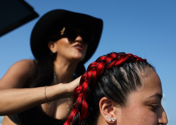 Leilani Terriquez has her hair braided with Mexican flag colors by Jessica Martinez before a White Sox-Royals game on Mexican Heritage Night at Rate Field on June 6, 2025, in Chicago. (John J. Kim/Chicago Tribune)