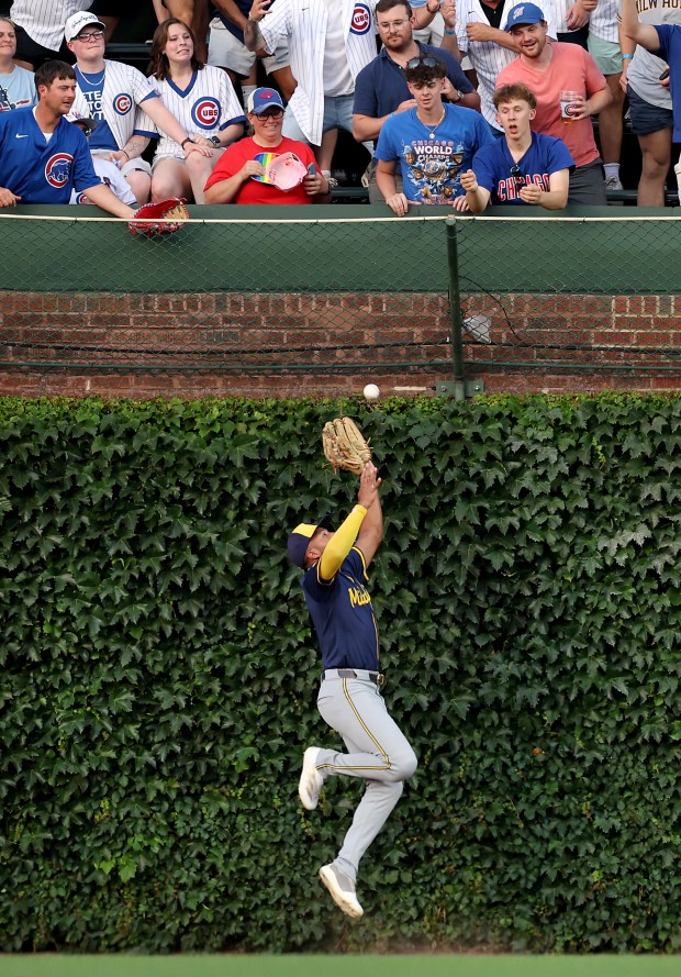 Brewers center fielder Jackson Chourio leaps but is unable to catch a deep fly ball that went for a double for Cubs right fielder Kyle Tucker in the first inning Tuesday, June 17, 2025, at Wrigley Field. (Chris Sweda/Chicago Tribune)