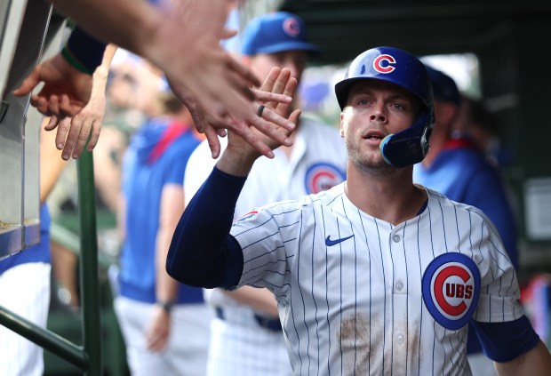 Cubs second baseman Nico Hoerner is congratulated in the dugout after scoring on a double by Matt Shaw in the second inning against the Brewers on Tuesday, June 17, 2025, at Wrigley Field. (Chris Sweda/Chicago Tribune)