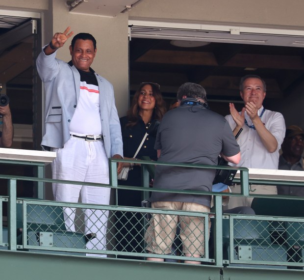 Former Chicago Cubs player Sammy Sosa acknowledges the applause from fans as he waves from a suite while being honored during a game between the Cubs and the Seattle Mariners at Wrigley Field in Chicago on June 20, 2025. Cubs chairman Tom Ricketts is at right. (Chris Sweda/Chicago Tribune)