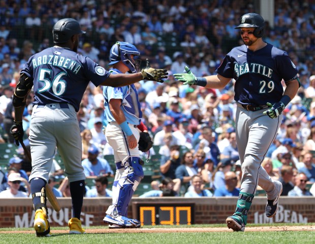 Mariners catcher Cal Raleigh (29) slaps hands with Randy Arozarena after hitting a solo home run in the first inning against the Cubs on June 20, 2025,at Wrigley Field. (Chris Sweda/Chicago Tribune)