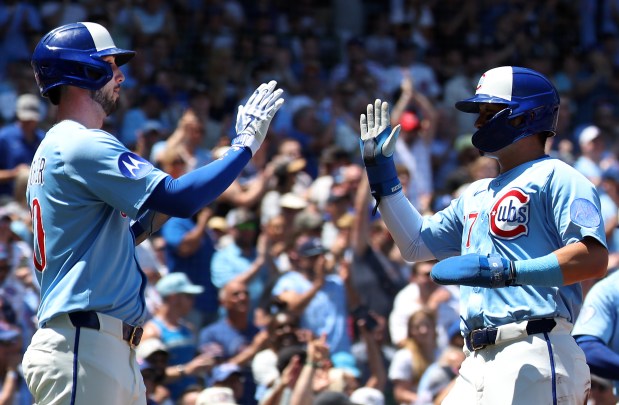 Kyle Tucker, left, and Seiya Suzuki celebrate after both scored on a Michael Busch single in the first inning against the Mariners on June 20, 2025, at Wrigley Field. (Chris Sweda/Chicago Tribune)