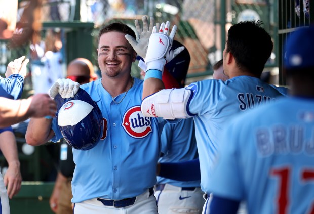 Cubs catcher Reese McGuire high-fives teammates in the dugout after hitting a solo home run in the fifth inning against the Mariners on Friday, June 20, 2025, at Wrigley Field. (Chris Sweda/Chicago Tribune)