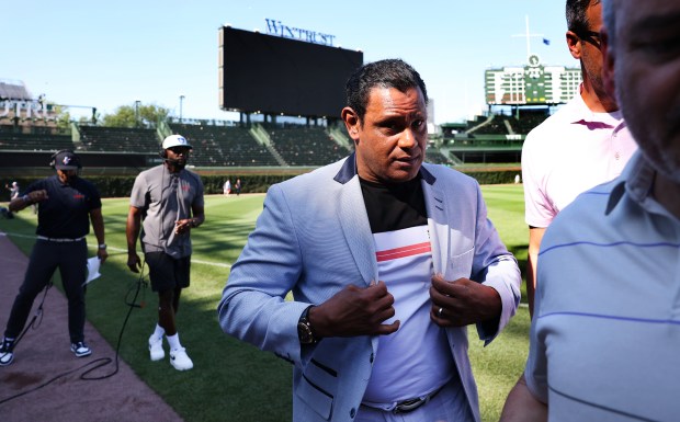 Former Cubs slugger Sammy Sosa fixes his jacket as he...