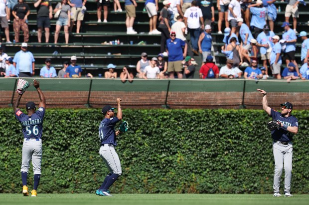Mariners outfielders celebrate after a 9-4 victory over the Cubs on Friday, June 20, 2025, at Wrigley Field. (Chris Sweda/Chicago Tribune)