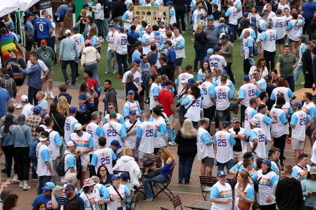 Fans wear Pride Chicago Cubs jerseys given out by the team as they hang out in Gallagher Way outside of Wrigley Field ahead of a game against the Pirates on June 12, 2025. (Chris Sweda/Chicago Tribune)