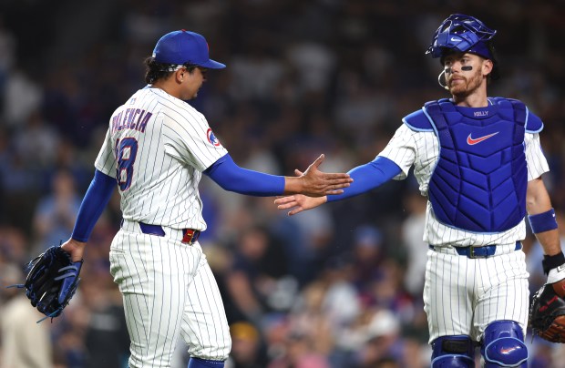 Cubs reliever Daniel Palencia, left, and catcher Carson Kelly slap hands another after shutting down the Pirates in the eighth inning on June 12, 2025, at Wrigley Field. (Chris Sweda/Chicago Tribune)