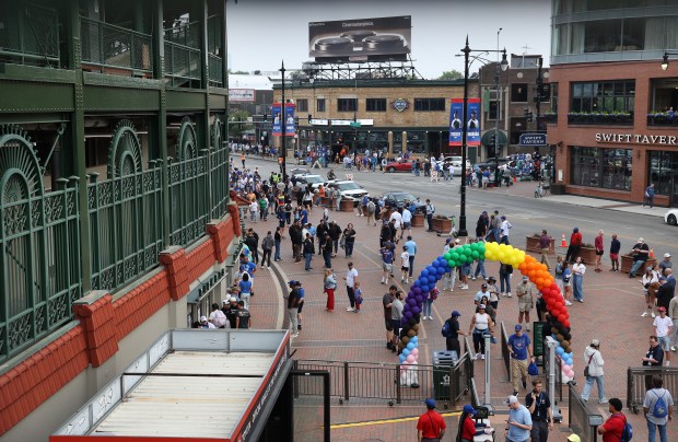 Fans enter Gallagher Way under a rainbow-colored balloon arch outside of Wrigley Field before a Cubs-Pirates game on Pride Night on June 12, 2025. (Chris Sweda/Chicago Tribune)