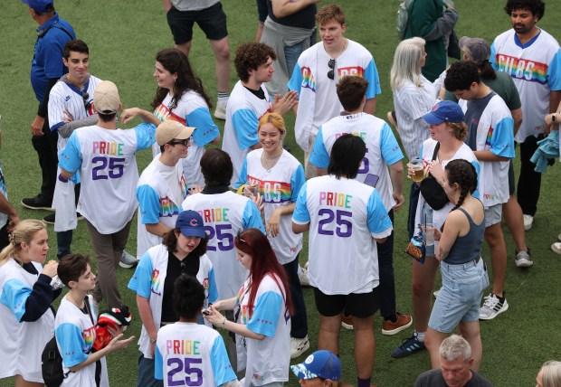Fans wear Pride Chicago Cubs jerseys given out by the team as they hang out in Gallagher Way outside of Wrigley Field ahead of a Cubs-Pirates game on June 12, 2025.  (Chris Sweda/Chicago Tribune)