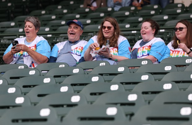 Michelle Harris, left to right, Marty Harris, Taylor Toombs, Rachael Poe and Brit Toombs have a laugh while relaxing in their seats while wearing Pride-themed Cubs jerseys given out by the team before a game against the Pirates on Pride Night at Wrigley Field on June 12, 2025. (Chris Sweda/Chicago Tribune)