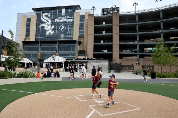 Chicago White Sox fans Jakob Rhinehart, 11, and his brother Micah Rhinehart, 8, of Chesterton, Indiana, take practice swings at the original Comiskey Park home plate outside of Rate Field prior to a game between the Sox and the Detroit Tigers on June 3, 2025. (Chris Sweda/Chicago Tribune)