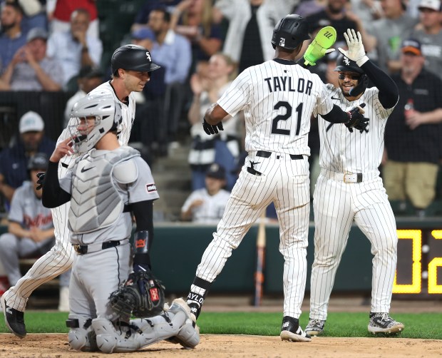 Chicago White Sox center fielder Michael A. Taylor (21) is congratulated by teammates Austin Slater (left) and Edgar Quero (right) after Taylor hit a three-run home run in the sixth inning of a game against the Detroit Tigers at Rate Field in Chicago on June 3, 2025. (Chris Sweda/Chicago Tribune)