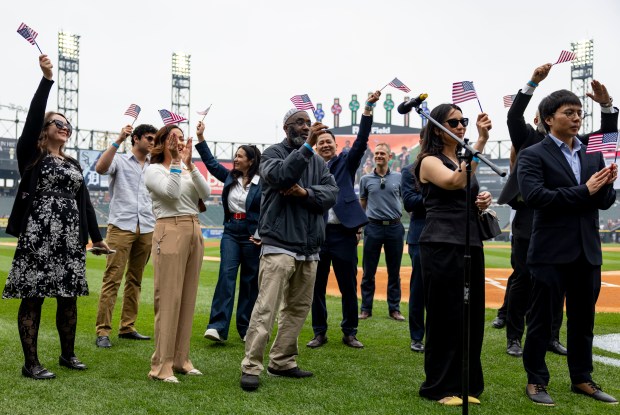 Twenty five new American citizens celebrate after taking the naturalization oath Thursday, June 5, 2025, during a ceremony on Rate Field before the White Sox faced the Tigers. Judge Matthew F. Kennelly performed the ceremony. (Brian Cassella/Chicago Tribune)