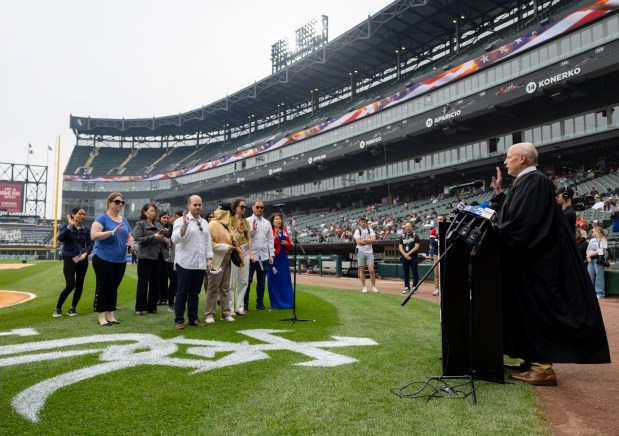Judge Matthew F. Kennelly swears in 25 new American citizens celebrate with the naturalization oath Thursday, June 5, 2025, during a ceremony on Rate Field before the White Sox faced the Tigers. (Brian Cassella/Chicago Tribune)