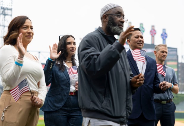 Twenty five new American citizens take the naturalization oath Thursday, June 5, 2025, during a ceremony on Rate Field before the White Sox faced the Tigers. Judge Matthew F. Kennelly performed the ceremony. (Brian Cassella/Chicago Tribune)