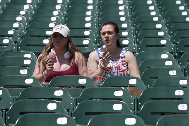 Fans cool off as they wait for a baseball game between the Seattle Mariners and the Chicago Cubs in Chicago, Sunday, June 22, 2025. (AP Photo/Nam Y. Huh)