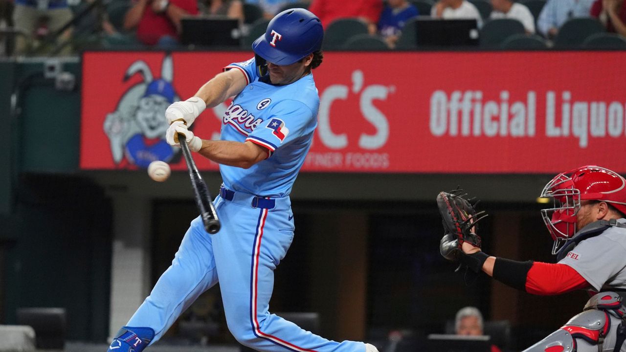 Texas Rangers' Josh Smith, left, hits a double that scored teammates Marcus Semien and Sam Haggerty in front of St. Louis Cardinals catcher Pedro Pagés during the second inning of a baseball game, Sunday, June 1, 2025, in Arlington, Texas. (AP Photo/LM Otero)