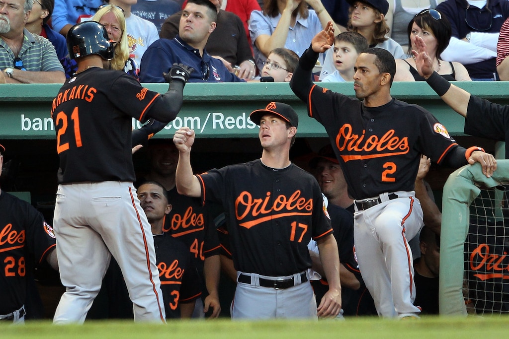 BOSTON - JULY 02: Brian Matusz #17 and Julio Lugo #2 of the Baltimore Orioles congratulate teammate Nick Markakis #21 after Markakis hit a solo home run in the fourth inning against the Boston Red Sox on July 2, 2010 at Fenway Park in Boston, Massachusetts.