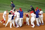 The Texas Rangers celebrate a walk-off single by second baseman Marcus Semien (2) in the...