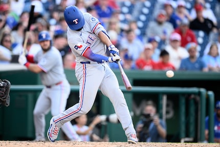 Texas Rangers' Marcus Semien drives in two runs as he hit a double during the eighth inning...