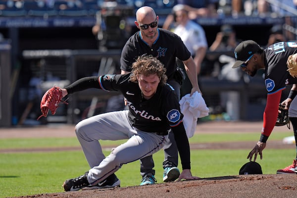 A Miami Marlins trainer helps pitcher Ryan Weathers get to his feet after he was hit in the head while teammatres were warming up before the first inning of a baseball game against the Tampa Bay Rays Saturday, June 7, 2025, in Tampa, Fla. (AP Photo/Chris O'Meara)