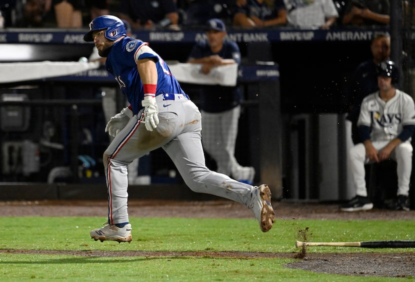Texas Rangers' Jake Burger singles to left field during the seventh inning of a baseball...