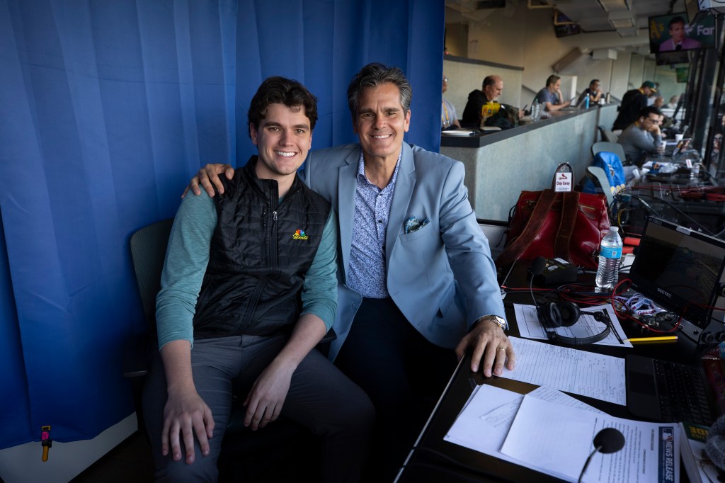 Two men sitting at a broadcast table during a St. Louis Cardinals vs. Oakland Athletics game.