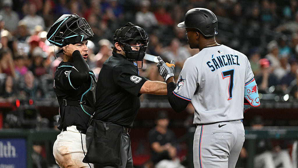 Home plate umpire Alex MacKay #9 gets in between Jose Herrera #11 of the Arizona Diamondbacks...