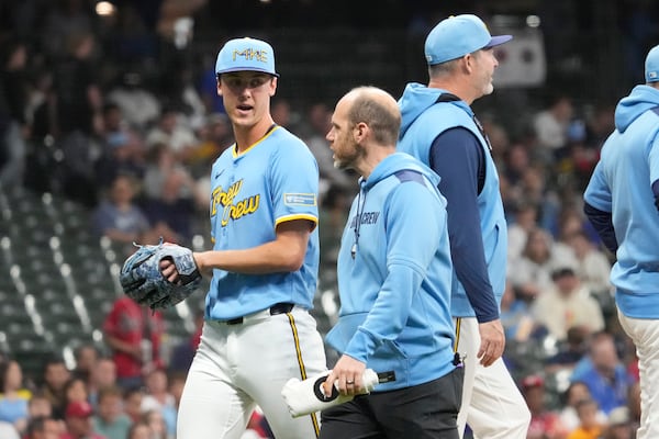 Milwaukee Brewers pitcher Jacob Misiorowski, left, walks off the field with head athletic trainer Brad Epstein, second from left, during the sixth inning of a baseball game against the St. Louis Cardinals, Thursday, June 12, 2025, in Milwaukee. (AP Photo/Kayla Wolf)