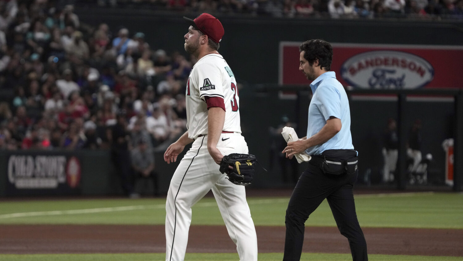 Arizona Diamondbacks pitcher Corbin Burnes, left, leaves a baseball game against the Washington Nat...
