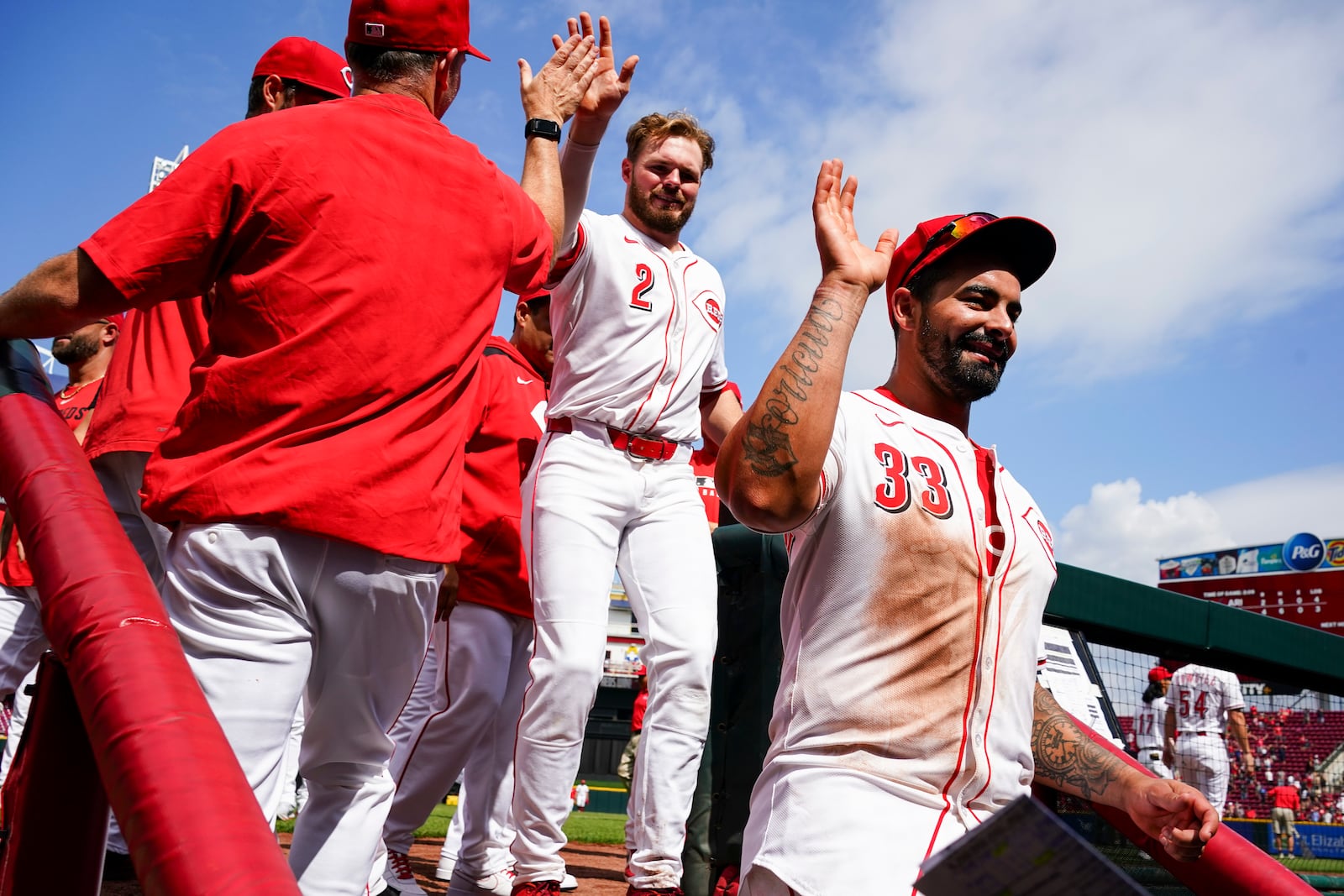 Cincinnati Reds' Christian Encarnacion-Strand (33) and Gavin Lux (2) celebrate with teammates following a baseball game against the Arizona Diamondbacks, Sunday, June 8, 2025, in Cincinnati. (AP Photo/Jeff Dean)