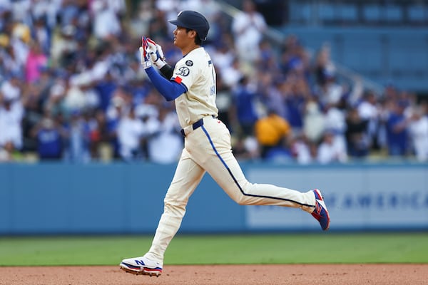 Los Angeles Dodgers designated hitter Shohei Ohtani gestures while running the bases after hitting a home run during the first inning inning of a baseball game against the San Francisco Giants in Los Angeles, Saturday, June 14, 2025. (AP Photo/Jessie Alcheh)