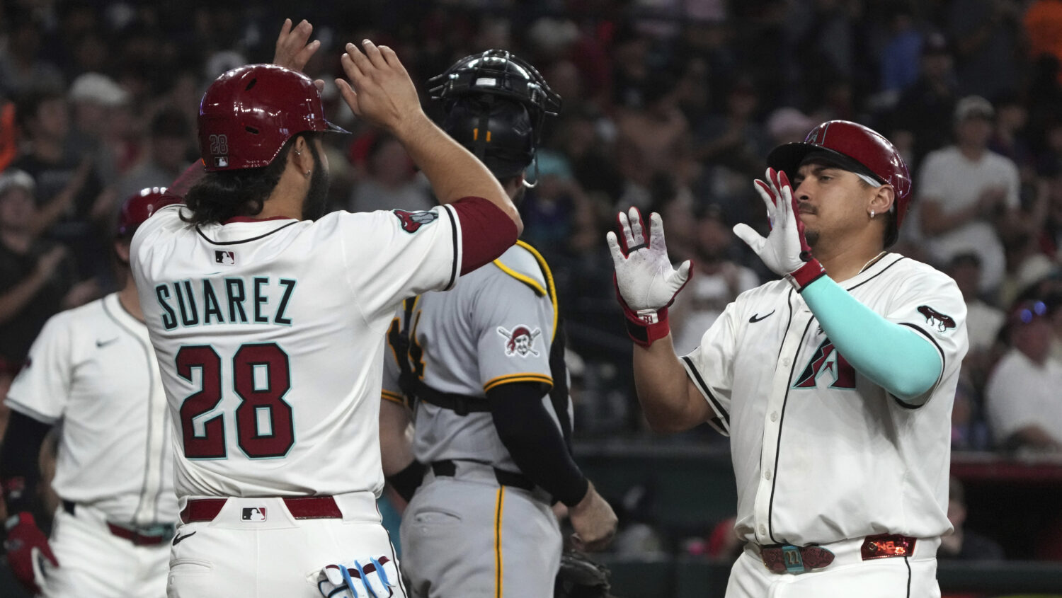 Arizona Diamondbacks' Josh Naylor, right, celebrates with Eugenio Suárez...