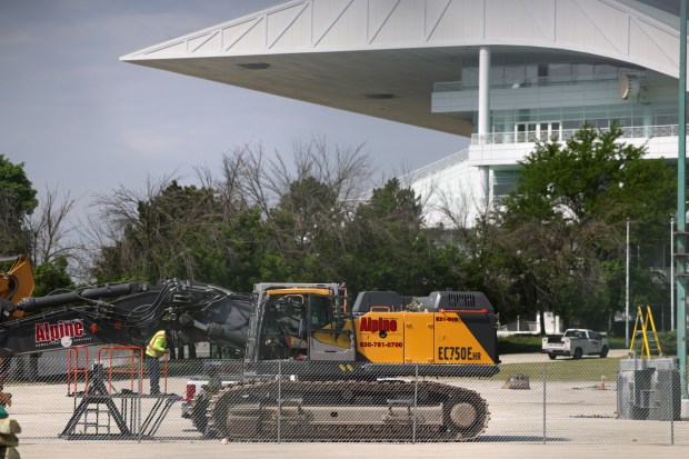 Workers gather in a parking lot outside of the former...